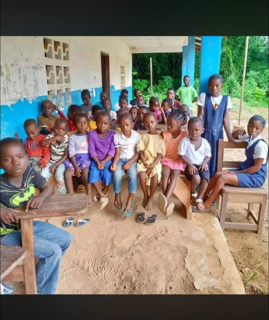 Students gathered outside their school building in the local learning environment.